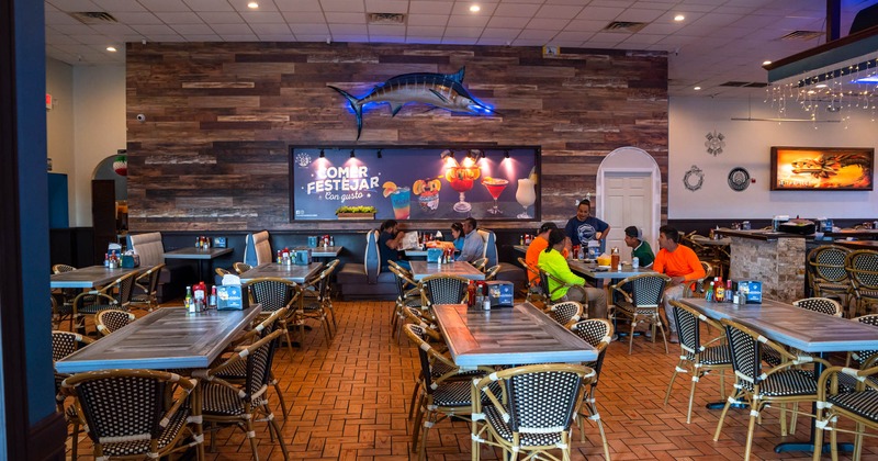 Interior, dining tables and booths with guests dining