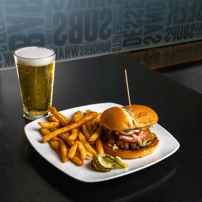 Classic cheeseburger and fries served with a glass of beer.