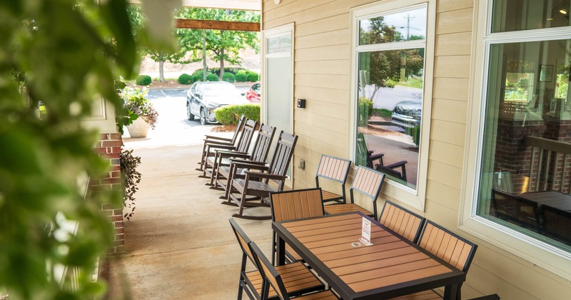 An outdoor seating area featuring a wooden table with chairs