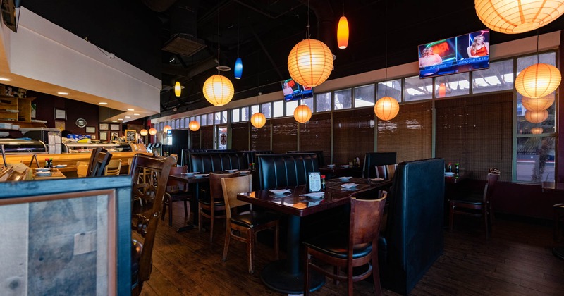 Interior, tables with tableware, chairs and black leather high back benches
