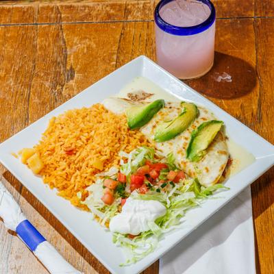 Quesadilla Jalisco topped with avocado slices, served with rice, sour creme and a salad.
