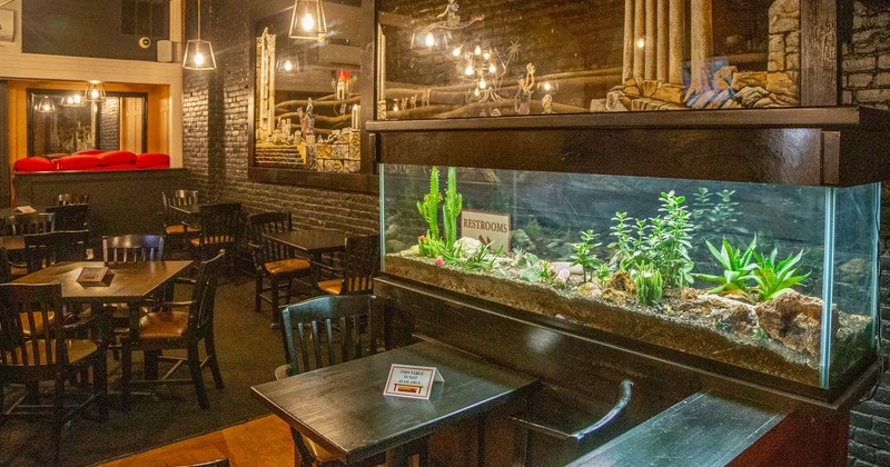 Interior, dining area, large fish tank, large painting on the wall, black brick walls