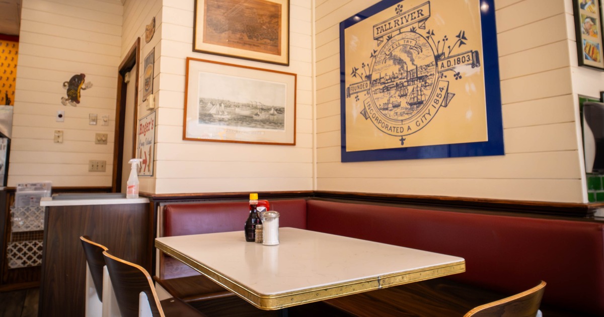 Diner corner - wooden table and chairs, red booth seating and wall art