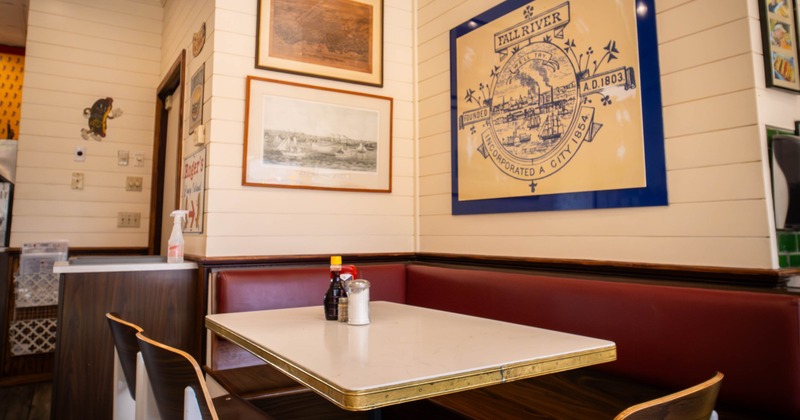 Diner corner - wooden table and chairs, red booth seating and wall art
