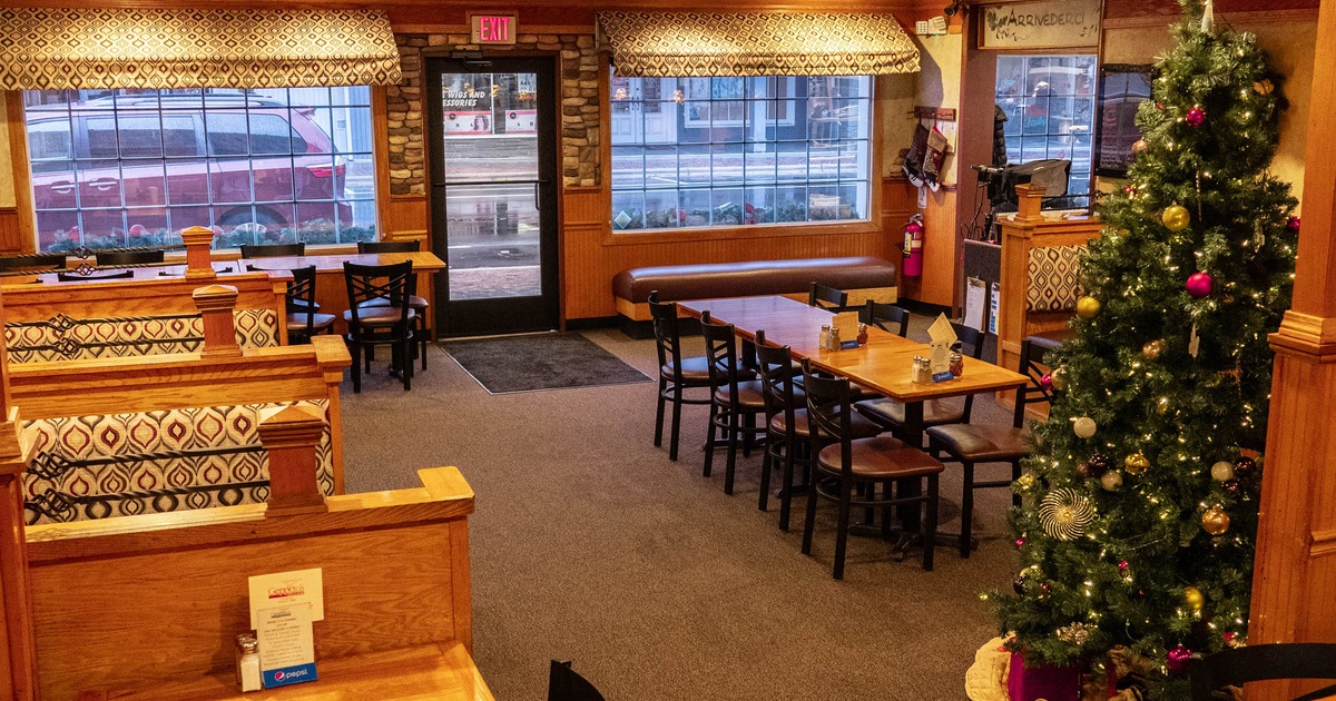 Empty restaurant interior featuring booths and a Christmas tree