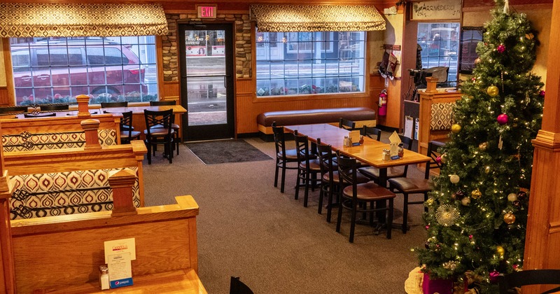 Empty restaurant interior featuring booths and a Christmas tree