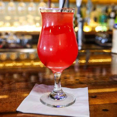 A glass of a red cocktail.