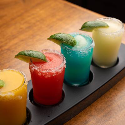 A colorful Margarita Flight with various frozen flavors.
