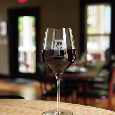 A glass of red wine on a table inside.