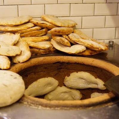 bread baking on side of traditional georgian 'tone' oven, like a tandoor