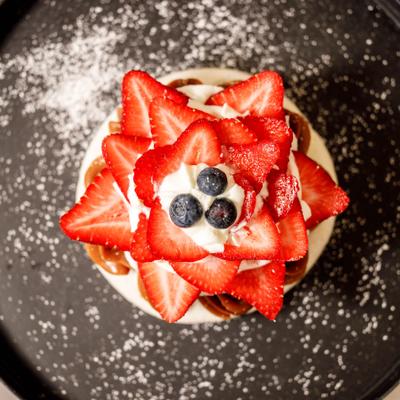 Pavlova dessert topped with whipped cream and fresh strawberries.