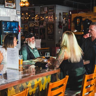 Owner conversing with guests at a table.