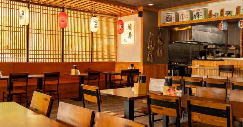 Interior of a Japanese-style restaurant with wooden furniture and paper lanterns