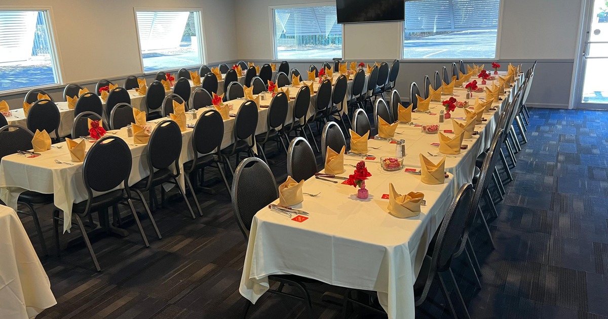 An elegant setup in a private dining room with a long set of tables prepared for a dinner gathering
