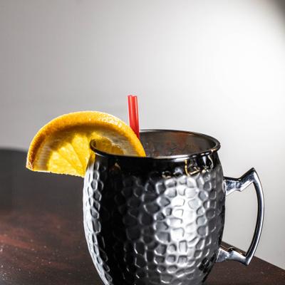 Mangia Mule cocktail, served in a metal mug with orange slice garnish.