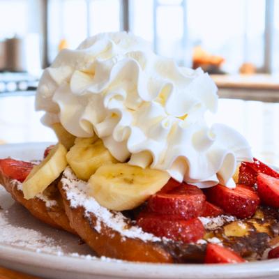 French Toast, topped with whipped cream and fruit.