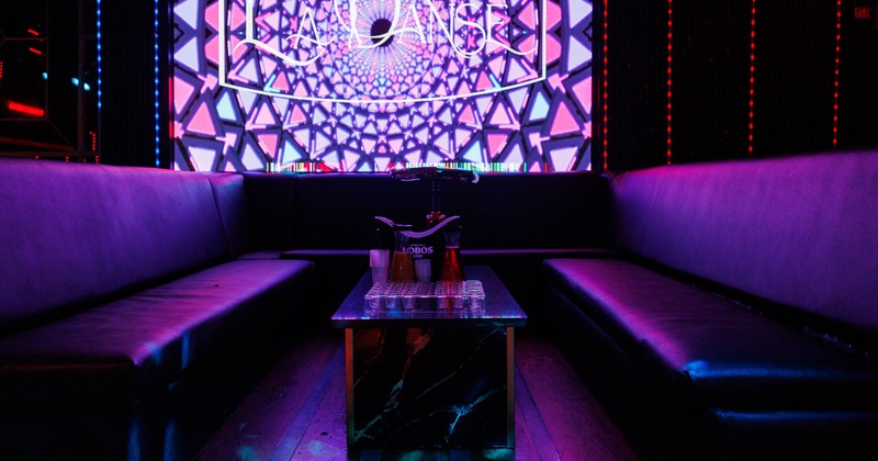 Lounge area with digital geometric display and black seating around a marble table.