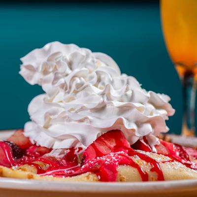 Crepe topped with whipped cream and berries.