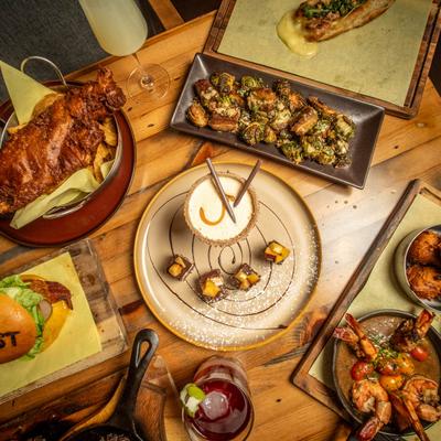 Assortment of dishes and drinks spread on a wooden table.