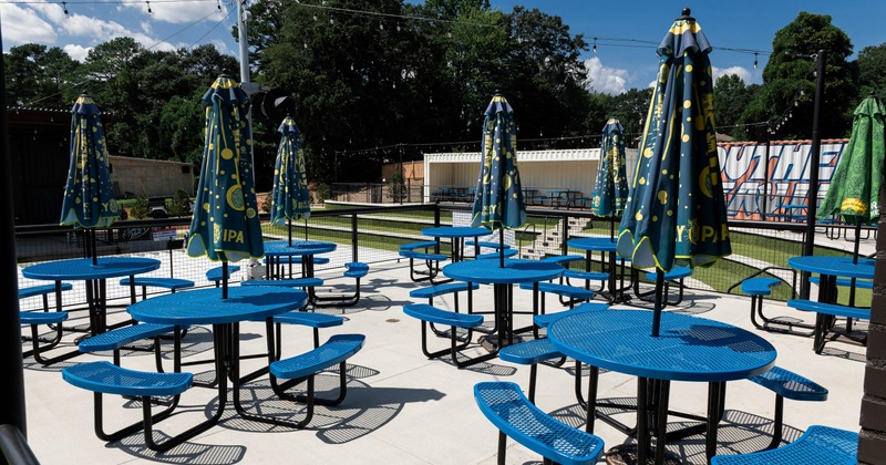 Outdoor seating area with blue tables and umbrellas