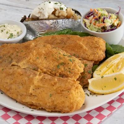Fried fish fillet, with coleslaw, baked potato, and tartar sauce.
