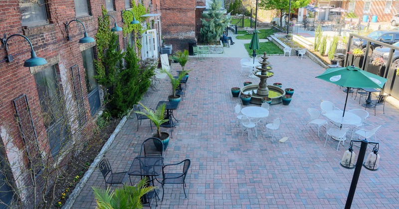 Exterior, tables and chairs on patio with fountain