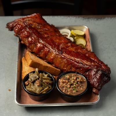 Full rack of pork ribs served with black-eyed peas, stewed green beans and bread.