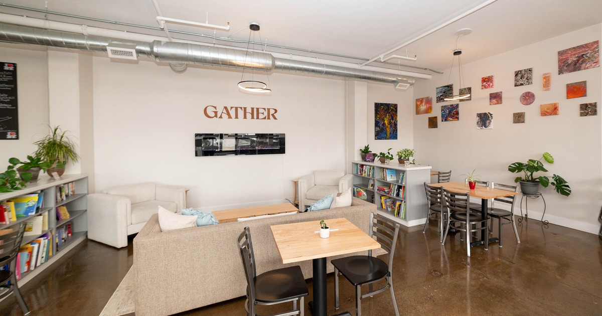 A modern communal space with seating, bookshelves, and colorful artwork on the walls