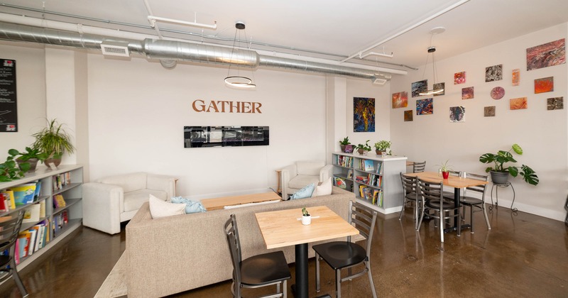A modern communal space with seating, bookshelves, and colorful artwork on the walls