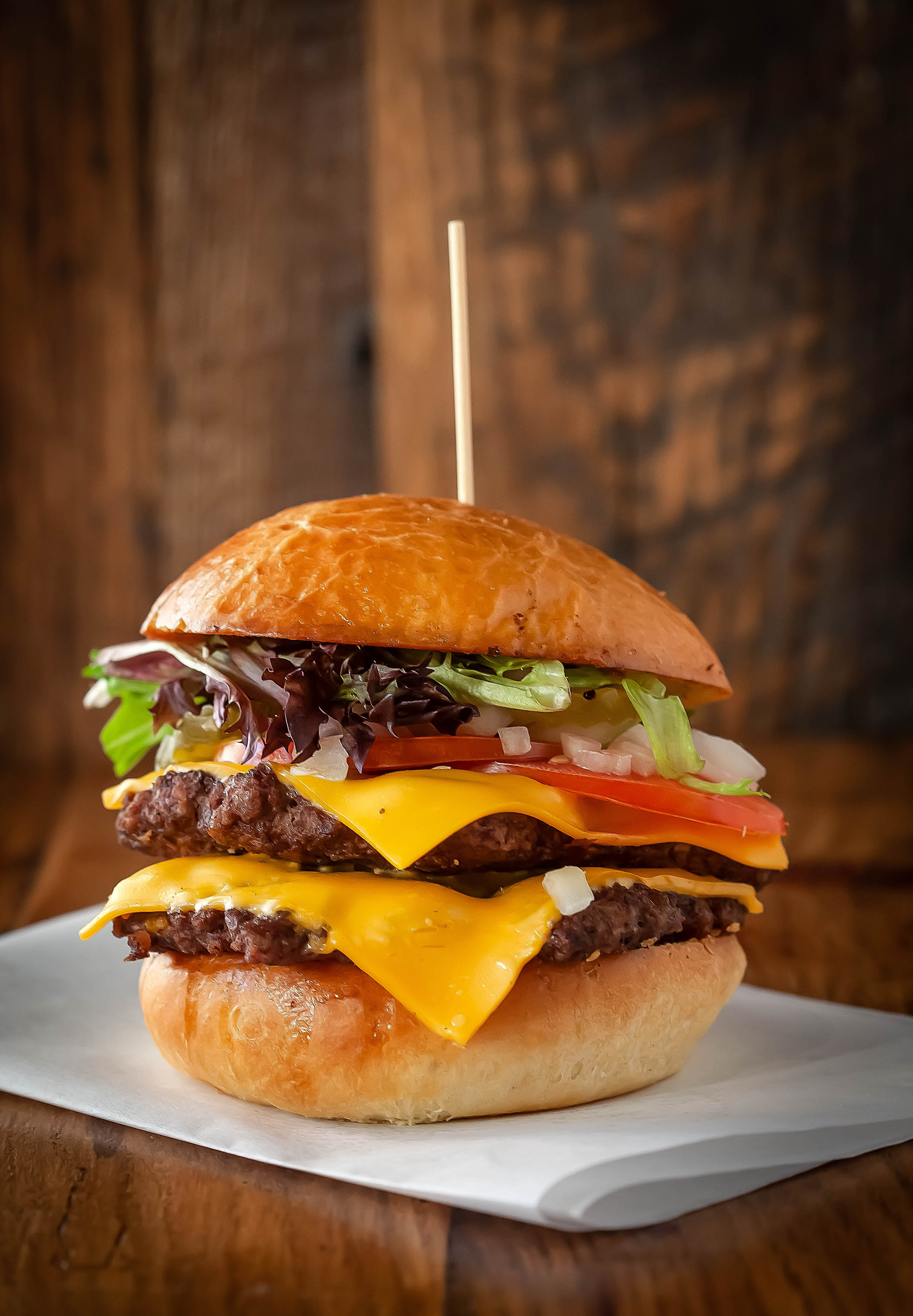 Double cheeseburger with melted cheddar, fresh lettuce, tomato, onions, and brioche bun