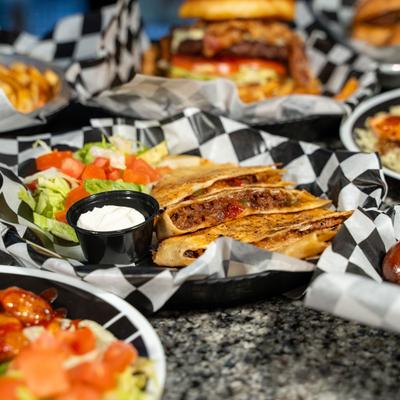 Assortment of dishes arranged on a table with beef quesadillas in the center.