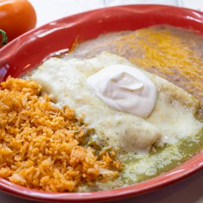 Enchiladas covered in melted cheese and green salsa, served with rice and refried beans.