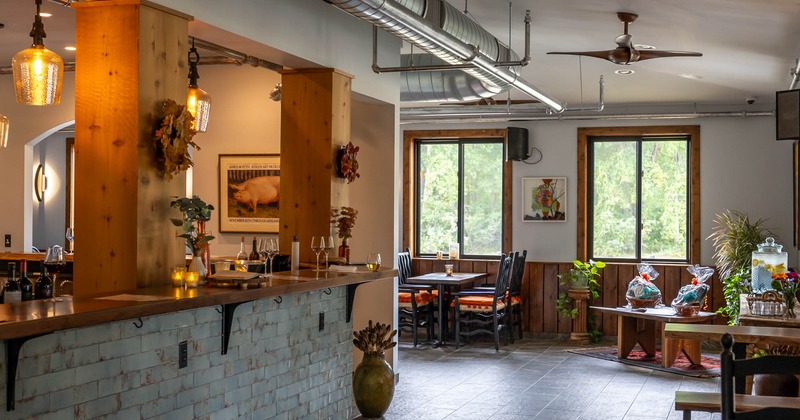 Interior, a bar at the left, tables with chairs on the other side