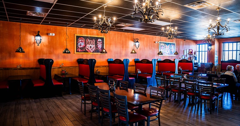 Interior, booths by the wall, tables and chairs in the middle