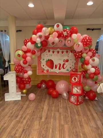 Interior, a room set up for a private event with pink and white balloons and a dessert station
