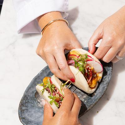 Hands reaching for bao buns.