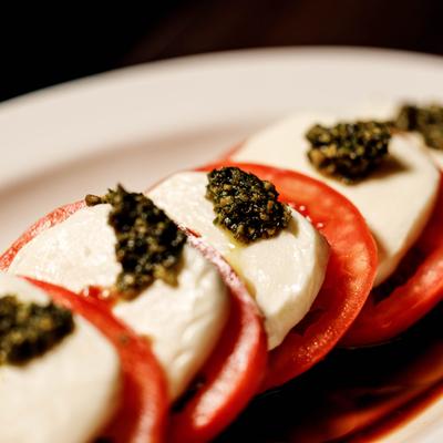 Caprese salad topped with basil pesto, close-up.