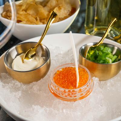 Caviar on ice, accompanied by scallions and cream.