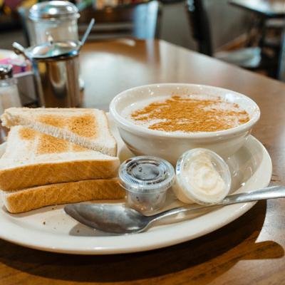 Oatmeal served with toasted bread, butter, and honey.