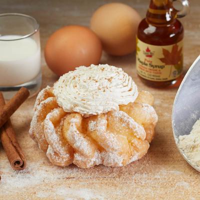 Powdered sugar pastry with whipped topping surrounded by baking ingredients.