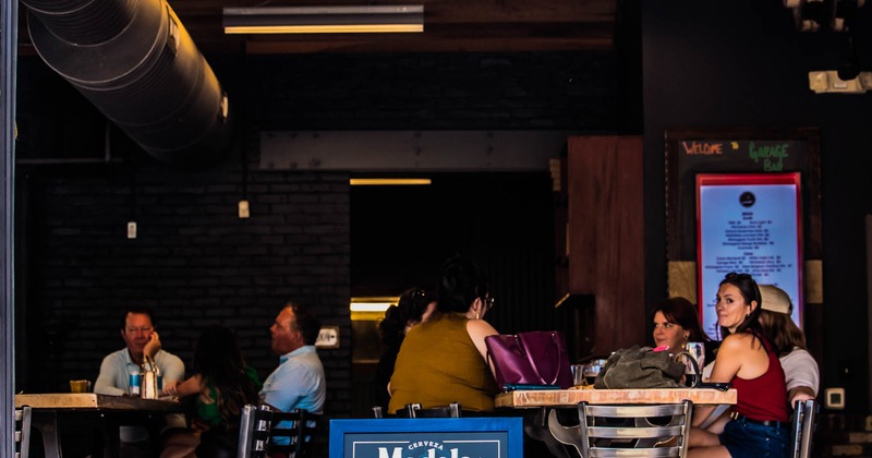 People sitting at tables inside a dimly lit restaurant