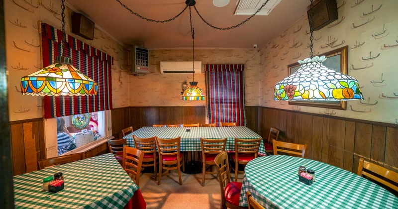 Retro dining room with tables covered in green checkered cloths and stained glass pendant lamps