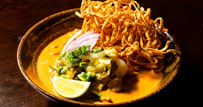 Coconut curry noodle soup topped with crispy, fried topping