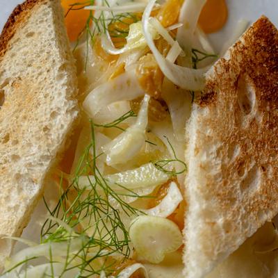 Toasted bread with feta cheese, raisins, shaved fennel, and herbs.