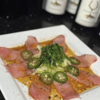 Thinly sliced yellowtail, with cucumber and seaweed salad, ponzu, chili oil, and jalapenos.