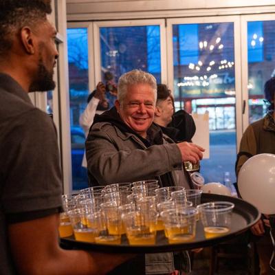 Employee carrying a tray of drinks.