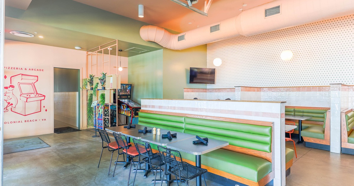 Interior, seating area with  green booths and arcade games