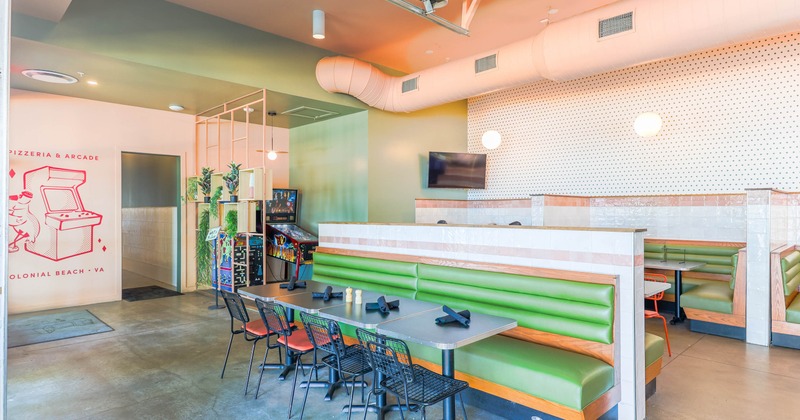 Interior, seating area with  green booths and arcade games