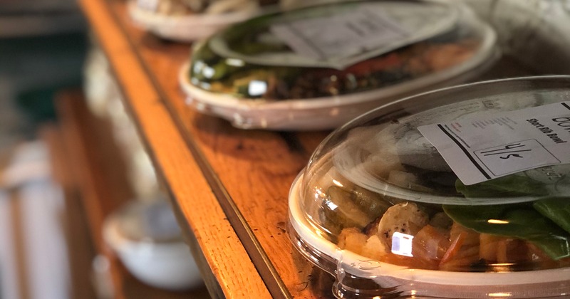 Short rib bowl and other to-go bowls on a shelf