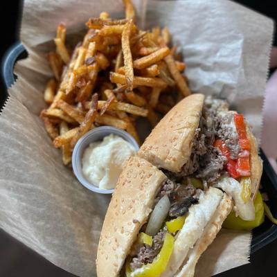 Philly cheese steak with fries and sauce dip